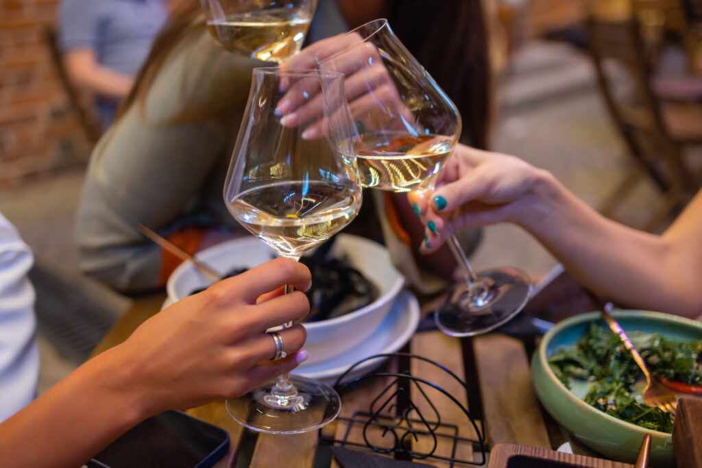 Clinking glasses with alcohol and toasting, party.